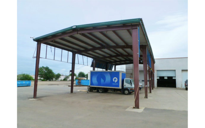 General Steel metal carport with green trim option. The image has a blue box truck in the carport.
